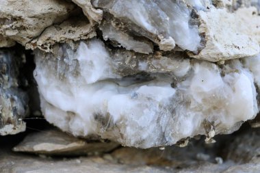 Farklı renkte kuvars kayaları. Gri, beyaz, turuncu kuvars depozitoları. Çeşitli taş birikintilerinde ve farklı kaya katmanlarında kalipdonik çeşitlilikte işlenmemiş yarı değerli taşlar..