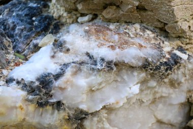 Farklı renkte kuvars kayaları. Gri, beyaz, turuncu kuvars depozitoları. Çeşitli taş birikintilerinde ve farklı kaya katmanlarında kalipdonik çeşitlilikte işlenmemiş yarı değerli taşlar..