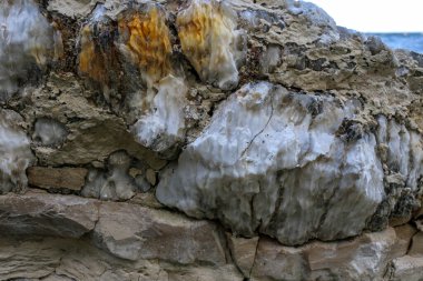 Farklı renkte kuvars kayaları. Gri, beyaz, turuncu kuvars depozitoları. Çeşitli taş birikintilerinde ve farklı kaya katmanlarında kalipdonik çeşitlilikte işlenmemiş yarı değerli taşlar..