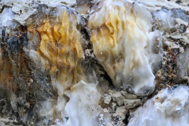 Farklı renkte kuvars kayaları. Gri, beyaz, turuncu kuvars depozitoları. Çeşitli taş birikintilerinde ve farklı kaya katmanlarında kalipdonik çeşitlilikte işlenmemiş yarı değerli taşlar..