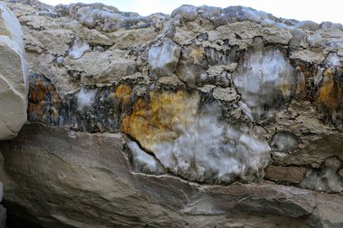 Farklı renkte kuvars kayaları. Gri, beyaz, turuncu kuvars depozitoları. Çeşitli taş birikintilerinde ve farklı kaya katmanlarında kalipdonik çeşitlilikte işlenmemiş yarı değerli taşlar..