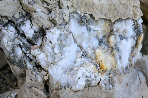 Farklı renkte kuvars kayaları. Gri, beyaz, turuncu kuvars depozitoları. Çeşitli taş birikintilerinde ve farklı kaya katmanlarında kalipdonik çeşitlilikte işlenmemiş yarı değerli taşlar..