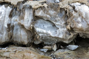 Farklı renkte kuvars kayaları. Gri, beyaz, turuncu kuvars depozitoları. Çeşitli taş birikintilerinde ve farklı kaya katmanlarında kalipdonik çeşitlilikte işlenmemiş yarı değerli taşlar..