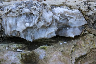 Farklı renkte kuvars kayaları. Gri, beyaz, turuncu kuvars depozitoları. Çeşitli taş birikintilerinde ve farklı kaya katmanlarında kalipdonik çeşitlilikte işlenmemiş yarı değerli taşlar..