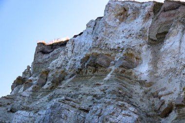 Alçıtaşı çıkarmak için bir taş ocağında kumlu alçıtaşı kesimi. Kum, kil, alçı taşı, kuvars ve alçı taşı içeren farklı toprak katmanlarının dağ dokuları erozyondan sonra.