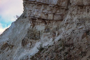 Alçıtaşı çıkarmak için bir taş ocağında kumlu alçıtaşı kesimi. Kum, kil, alçı taşı, kuvars ve alçı taşı içeren farklı toprak katmanlarının dağ dokuları erozyondan sonra.