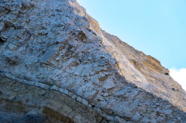 Alçıtaşı çıkarmak için bir taş ocağında kumlu alçıtaşı kesimi. Kum, kil, alçı taşı, kuvars ve alçı taşı içeren farklı toprak katmanlarının dağ dokuları erozyondan sonra.