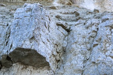 Alçıtaşı çıkarmak için bir taş ocağında kumlu alçıtaşı kesimi. Kum, kil, alçı taşı, kuvars ve alçı taşı içeren farklı toprak katmanlarının dağ dokuları erozyondan sonra.