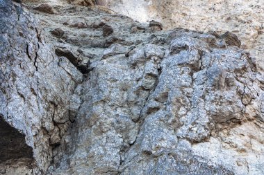 Alçıtaşı çıkarmak için bir taş ocağında kumlu alçıtaşı kesimi. Kum, kil, alçı taşı, kuvars ve alçı taşı içeren farklı toprak katmanlarının dağ dokuları erozyondan sonra.