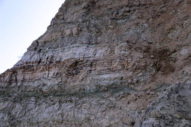 Alçıtaşı çıkarmak için bir taş ocağında kumlu alçıtaşı kesimi. Kum, kil, alçı taşı, kuvars ve alçı taşı içeren farklı toprak katmanlarının dağ dokuları erozyondan sonra.