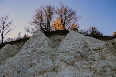 Alçıtaşı çıkarmak için bir taş ocağında kumlu alçıtaşı kesimi. Kum, kil, alçı taşı, kuvars ve alçı taşı içeren farklı toprak katmanlarının dağ dokuları erozyondan sonra.