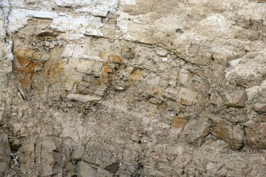 Alçıtaşı çıkarmak için bir taş ocağında kumlu alçıtaşı kesimi. Kum, kil, alçı taşı, kuvars ve alçı taşı içeren farklı toprak katmanlarının dağ dokuları erozyondan sonra.