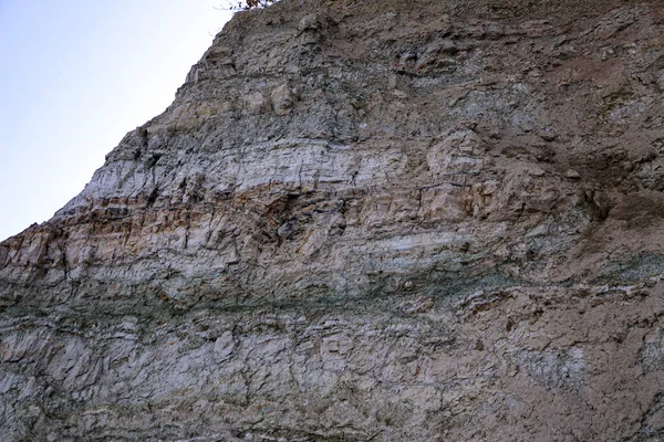 Alçıtaşı çıkarmak için bir taş ocağında kumlu alçıtaşı kesimi. Kum, kil, alçı taşı, kuvars ve alçı taşı içeren farklı toprak katmanlarının dağ dokuları erozyondan sonra.