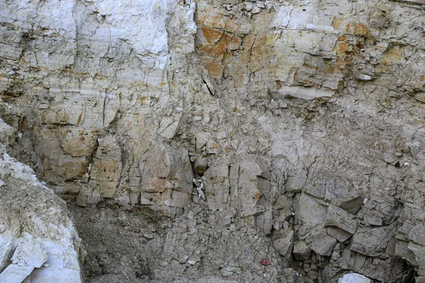 Alçıtaşı çıkarmak için bir taş ocağında kumlu alçıtaşı kesimi. Kum, kil, alçı taşı, kuvars ve alçı taşı içeren farklı toprak katmanlarının dağ dokuları erozyondan sonra.