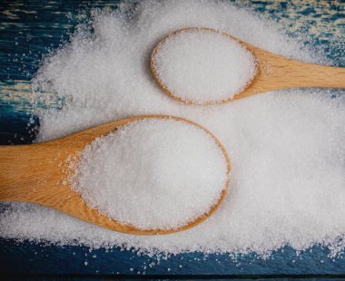 Beyaz Rafineri Kaşıklı Şeker Masa 'da yatıyordu. Top View, yakın çekim. Tatlı ama sağlıksız. Tablo Katmanı