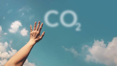 CO2 sembolüyle gökyüzüne uzanan eller, çevresel farkındalığı, hava kalitesini ve iklim hareketini sembolize ediyor