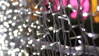 LED ampullü bir caddenin dekorasyonu el kameralı bir video. Mutlu yıllar ve Xmas teması. Bulanık, pırıl pırıl çelenk ışıkları, soyut, bulanık arkaplan.