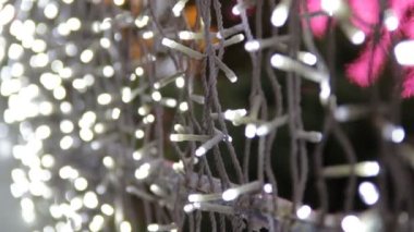 LED ampullü bir caddenin dekorasyonu el kameralı bir video. Mutlu yıllar ve Xmas teması. Bulanık, pırıl pırıl çelenk ışıkları, soyut, bulanık arkaplan.