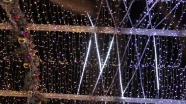 Striptiz lambalı bir caddenin dekorasyonu. Mutlu yıllar ve Xmas temalı. Bulanık, pırıl pırıl çelenk ışıkları olan bir sokak..