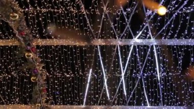 Soyunma lambasıyla süslenmiş bir cadde. Mutlu yıllar ve Xmas teması. Bulanık, pırıl pırıl çelenk ışıkları olan bir sokak..