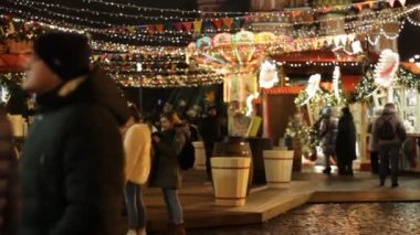 MOSCOW, RUSSIA - 23 Aralık 2019: Moskova 'nın Kızıl Meydan kentindeki Noel pazarındaki insanlar, Moskova' da yeni yıl için Kızıl Meydan 'ı süsleyip aydınlattılar. Arka planda Basil Katedrali