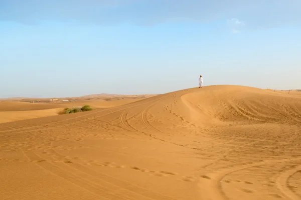 Photo of local resident standing on a dune of a desert in the Un — Stock Photo, Image