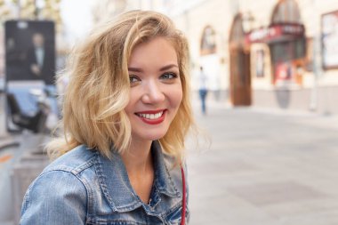 Beyaz etekli ve kırmızı bluzlu güzel bir kız. Parkta ve şehirde yürümek