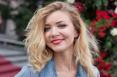 Kot ceketli güzel bir kız. Parkta ve şehirde yürümek