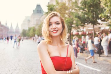 Beyaz etekli ve kırmızı bluzlu güzel bir kız. Parkta ve şehirde yürümek