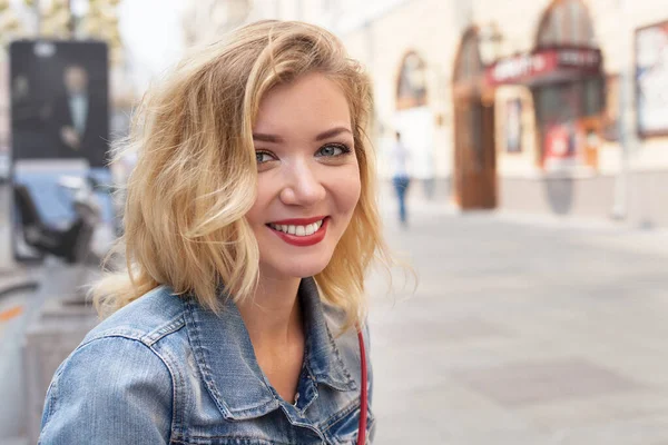 Beyaz etekli ve kırmızı bluzlu güzel bir kız. Parkta ve şehirde yürümek