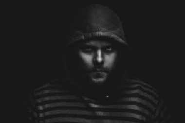 Siyah arka planda kapüşonlu bir adamın şeytani dramatik portresi. vektör