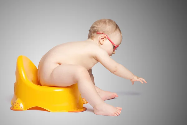 Little baby with glasses sitting on the toilet — Stock Photo, Image
