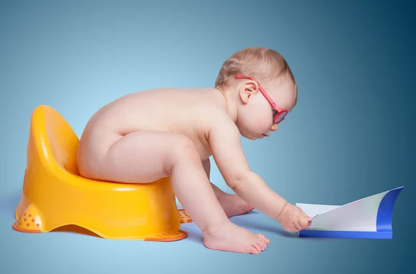 Little baby with glasses sitting on the toilet — Stock Photo, Image
