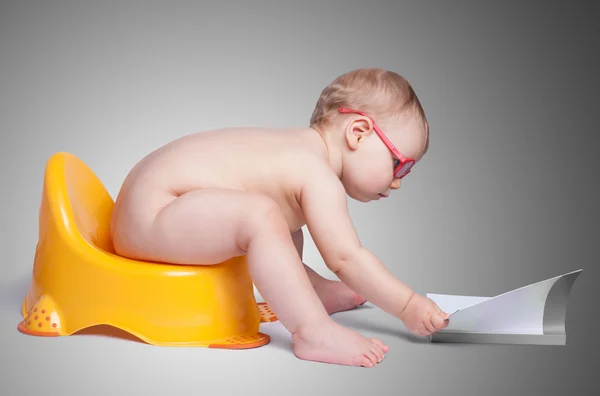 Little baby with glasses sitting on the toilet — Stock Photo, Image