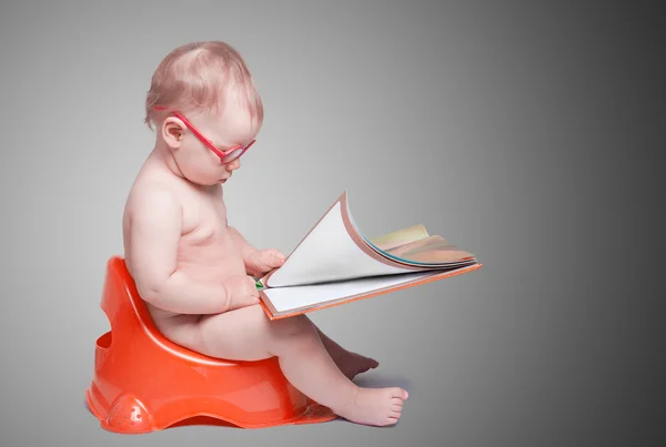 Little baby with glasses sitting on the toilet — Stock Photo, Image