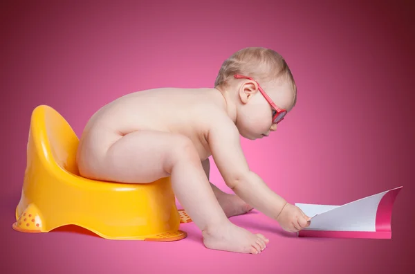 Little baby with glasses sitting on the toilet — Stock Photo, Image