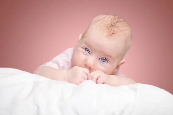 Malá holčička leží na polštář — Stock fotografie