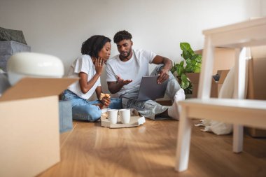 Katta oturan çift dizüstü bilgisayarla planları tartışıyor.