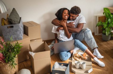 Kutularla çevrili bir çift yerde oturuyor.