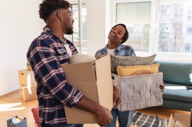 Çift yeni evine taşınıyor. Kutular ve yastıklar taşıyor.