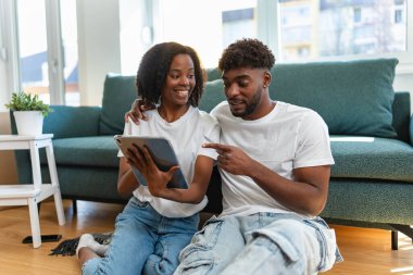 Tablet kullanan ve birlikte gülümseyen bir çift.