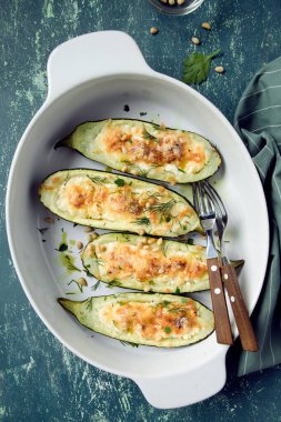 Fırında kabak, süzme peynir, parmesan, sarımsak, dereotu ve çam fıstığı ile doldurulmuş. Yeşil eski püskü kırsal arka plan.
