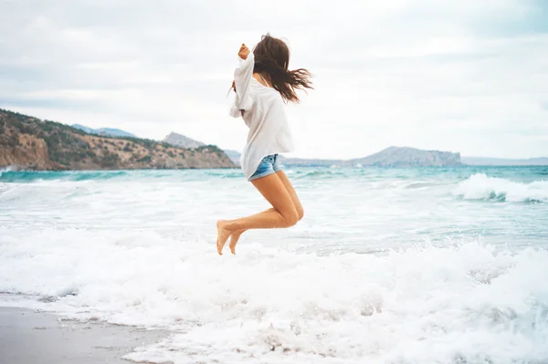 Schöne junge Frau zu Fuß am Meer — Stockfoto