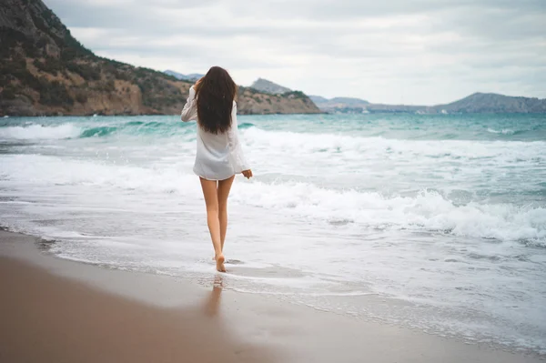 Schöne junge Frau zu Fuß am Meer — Stockfoto