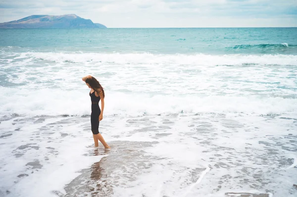 Schöne junge Frau zu Fuß am Meer — Stockfoto