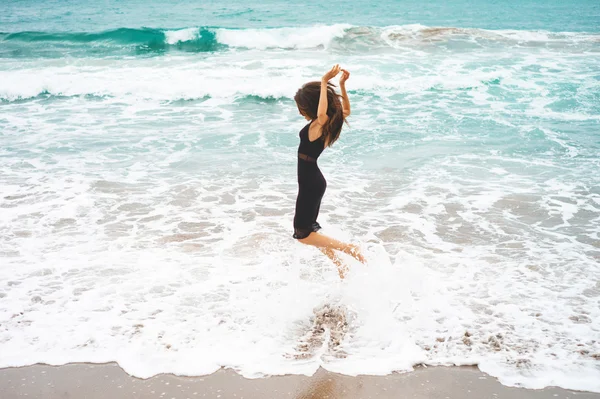 Schöne junge Frau zu Fuß am Meer — Stockfoto