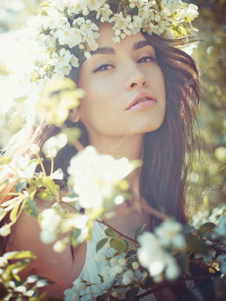 Romantic lady in a wreath of apple trees 