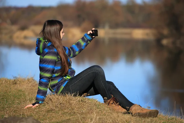 若い女の子が彼女の携帯電話を使用して写真を加える — ストック写真