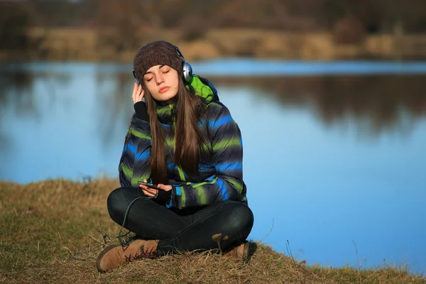 Junges Mädchen sitzt nach Wanderung auf dem Boden und hört Musik — Stockfoto