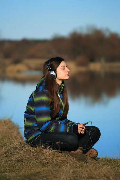 Junges Mädchen sitzt nach Wanderung auf dem Boden und hört Musik — Stockfoto
